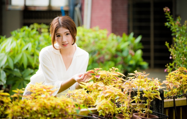 Молодая девушка азиатка с комнатными цветами