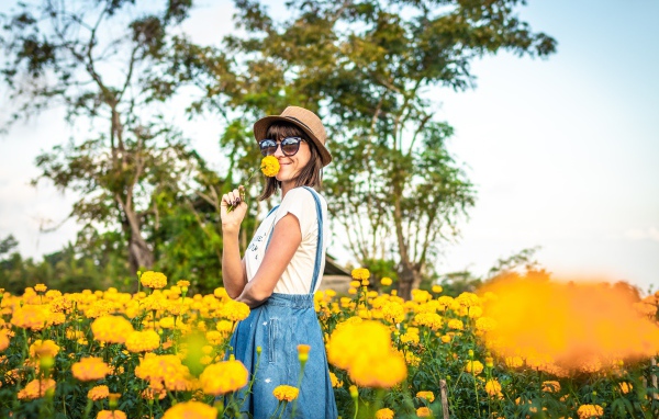 Молодая девушка в солнечных очках в желтых цветах 