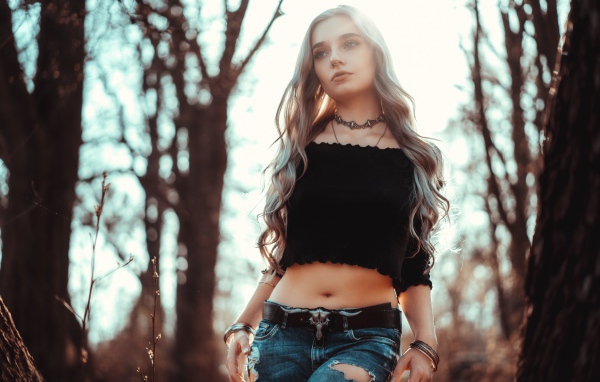 Молодая девушка в рваных джинсах с пирсингом в носу