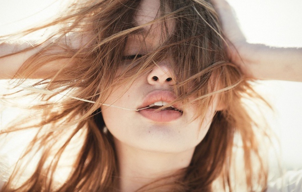 Молодая девушка с распущенными волосами на ветру