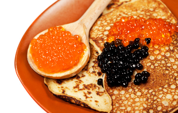 Ruddy appetizing pancakes with red and black caviar on Shrovetide