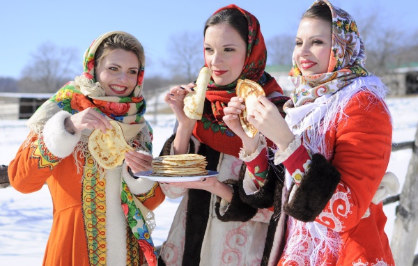 Три молодые красивые девушки с блинами на Масленицу