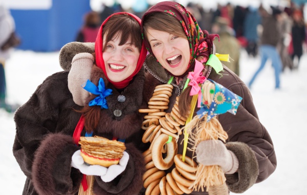 Две девушки с блинами и баранками на Масленицу