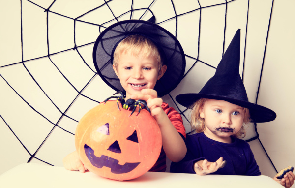 Маленькие мальчик и девочка в костюмах на Хэллоуин