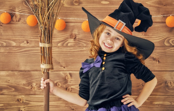 Маленькая девочка в костюме ведьмы на праздник Хэллоуин