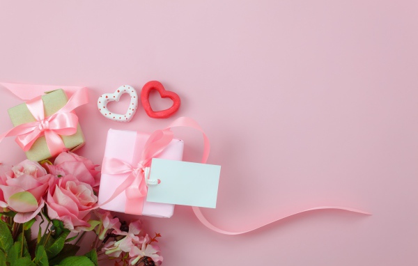 Букет роз, подарки и два сердца на розовом фоне шаблон открытки на 8 марта
