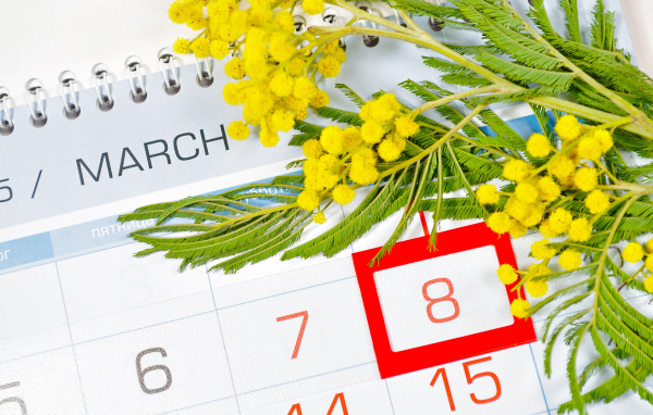 Ветка желтой мимозы и календарь на Международный женский день