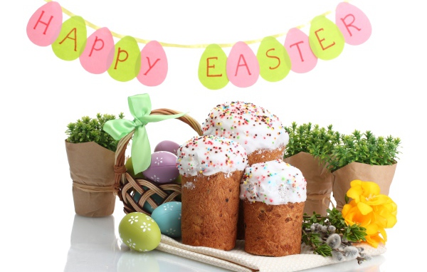 Куличи и крашеные яйца с цветами на белом фоне на праздник Пасха