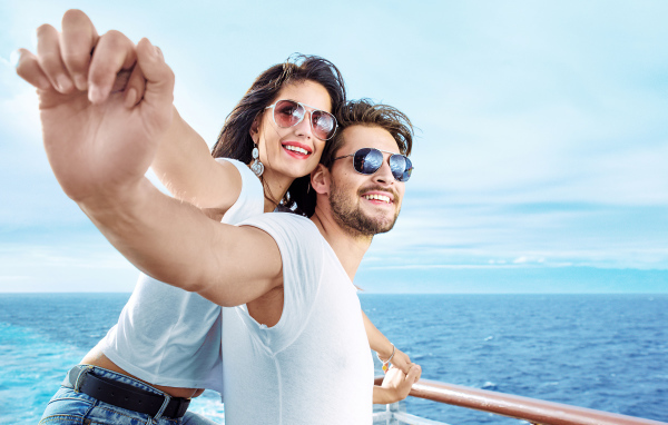 Влюбленная пара держится за руки на фоне моря