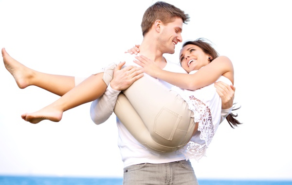 Влюбленный парень держит девушку на руках