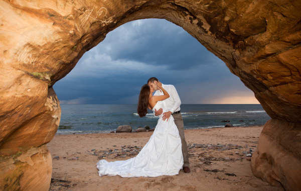 Поцелуй жениха и невесты на фоне моря