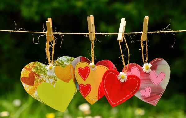 Бумажные сердечки висят на веревке на прищепках