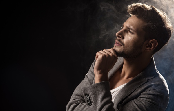 Красивый задумчивый мужчина в сером пиджаке