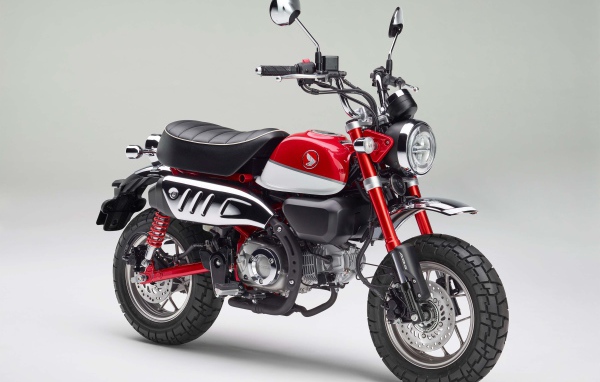 Красный мотоцикл Honda Monkey, 2018 года на сером фоне