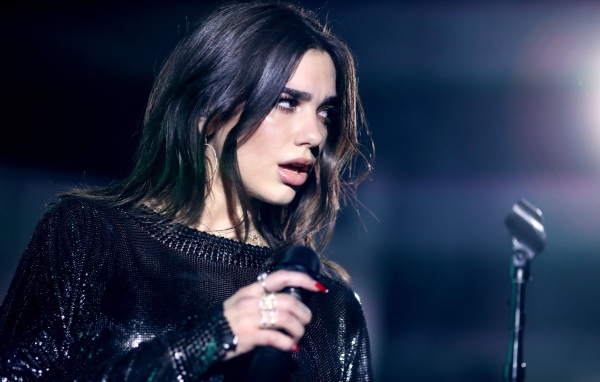 Британская певица Дуа Липа с микрофоном в руках