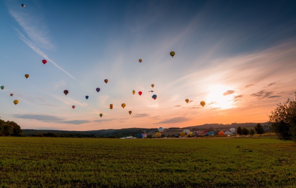 Воздушные шары в небе над зеленым полем