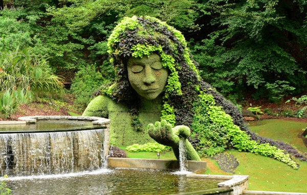 Красивый водопад в парке со скульптурой 