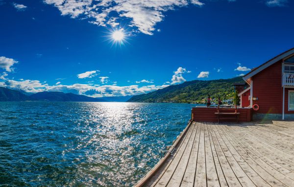 Яркое солнце в голубом небе над водой, Исландия