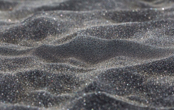 Блестящий черный песок крупным планом
