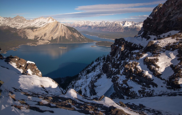 Озеро между заснеженных гор на фоне голубого неба