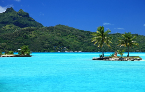 Маленькие островки с пальмами в голубом океане 