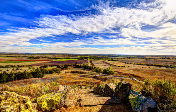 Вид на поле под красивым голубым небом с белыми облаками