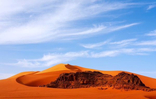 Оранжевая горячая пустыня Сахара под голубым небом