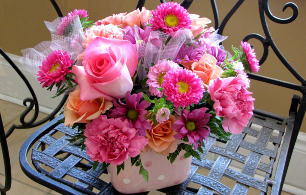 Красивый букет стоит на железном стуле