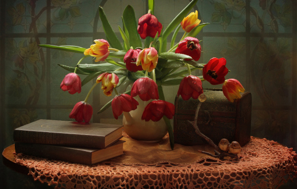 Букет тюльпанов на столе с книгами и шкатулкой