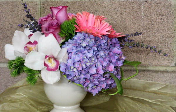 Красивый букет в белой вазе на фоне стены 