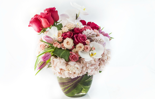 Красивый букет цветов в вазе на белом фоне