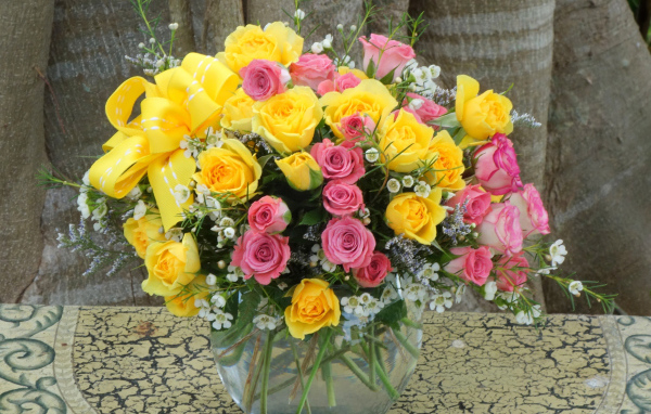Букет желтых и розовых роз в стеклянной вазе