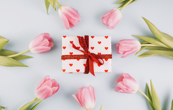 Подарок с розовыми тюльпанами на сером фоне 