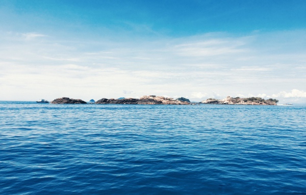 Спокойное синее море со скалами на горизонте