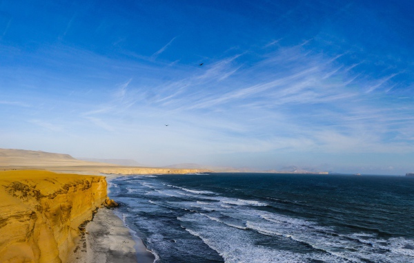 Морские волны на берегу под красивым голубым небом