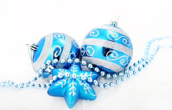 Красивые голубые елочные шарики со звездой и бусами на белом фоне