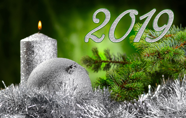 Красивый серебряный шар и свеча с еловой веткой на Новый год и Рождество 2019 