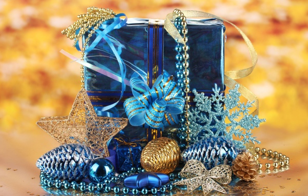 Большой подарок в голубой упаковке с украшениями на Новый год 