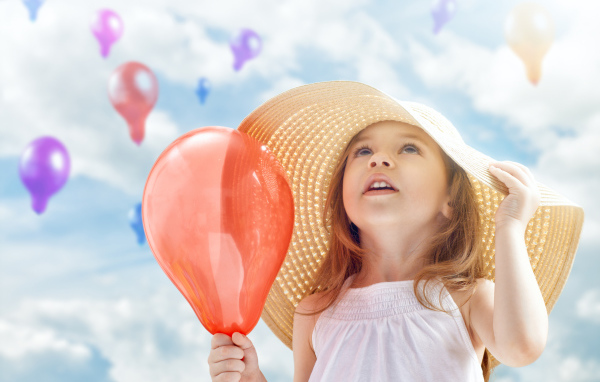 Девочка в большой шляпе с красным надувным шариком