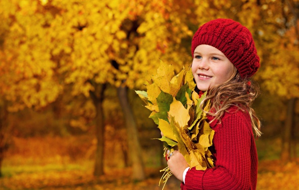 Девочка в красном берете с желтыми листьями в руках