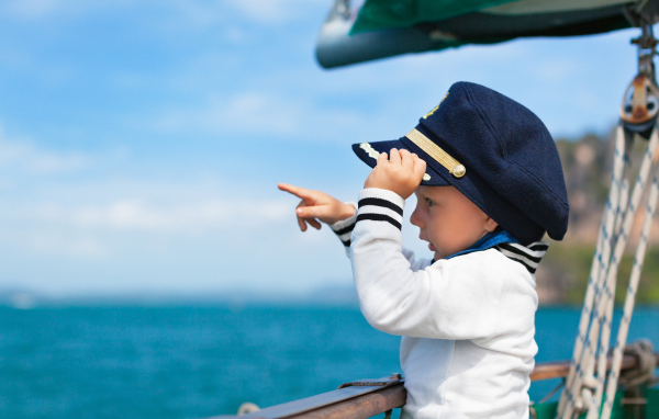 Маленький мальчик в форме капитана на корабле