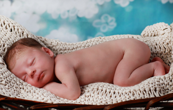 Маленький спящий грудной ребенок в колыбели