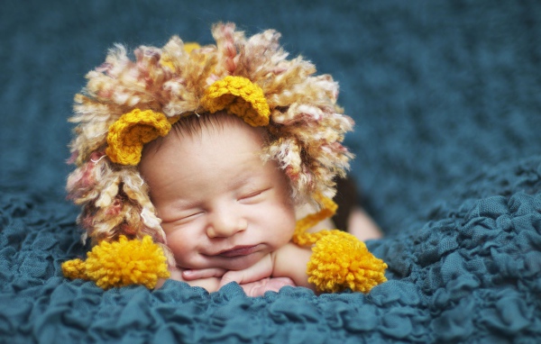 Милый спящий младенец в забавной шапке львенка