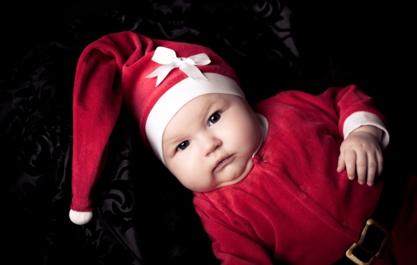 Грудной ребенок в красном новогоднем костюме