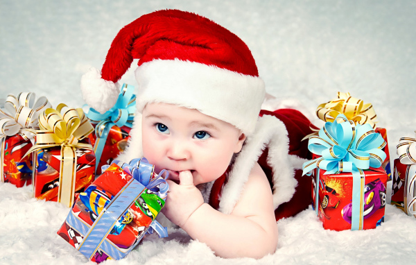 Маленький ребенок в новогоднем костюме с подарками