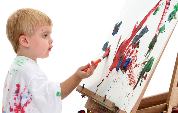 Маленький мальчик рисует красками 