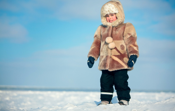 Little boy in a warm coat on the snow