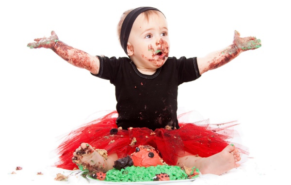 Маленькая смешная девочка в торте на белом фоне