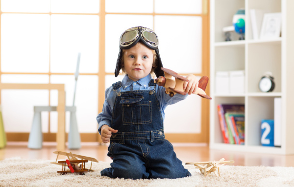 Маленький будущий летчик играет с самолетом