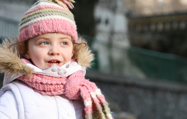 Маленькая девочка в теплой шапке с шарфом
